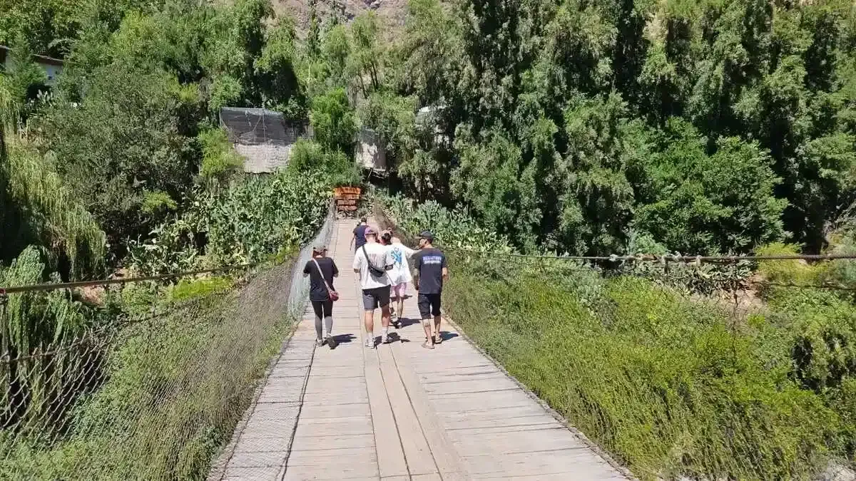 Wooden suspension bridge leading into Cascada de las Ánimas sanctuary in San Alfonso