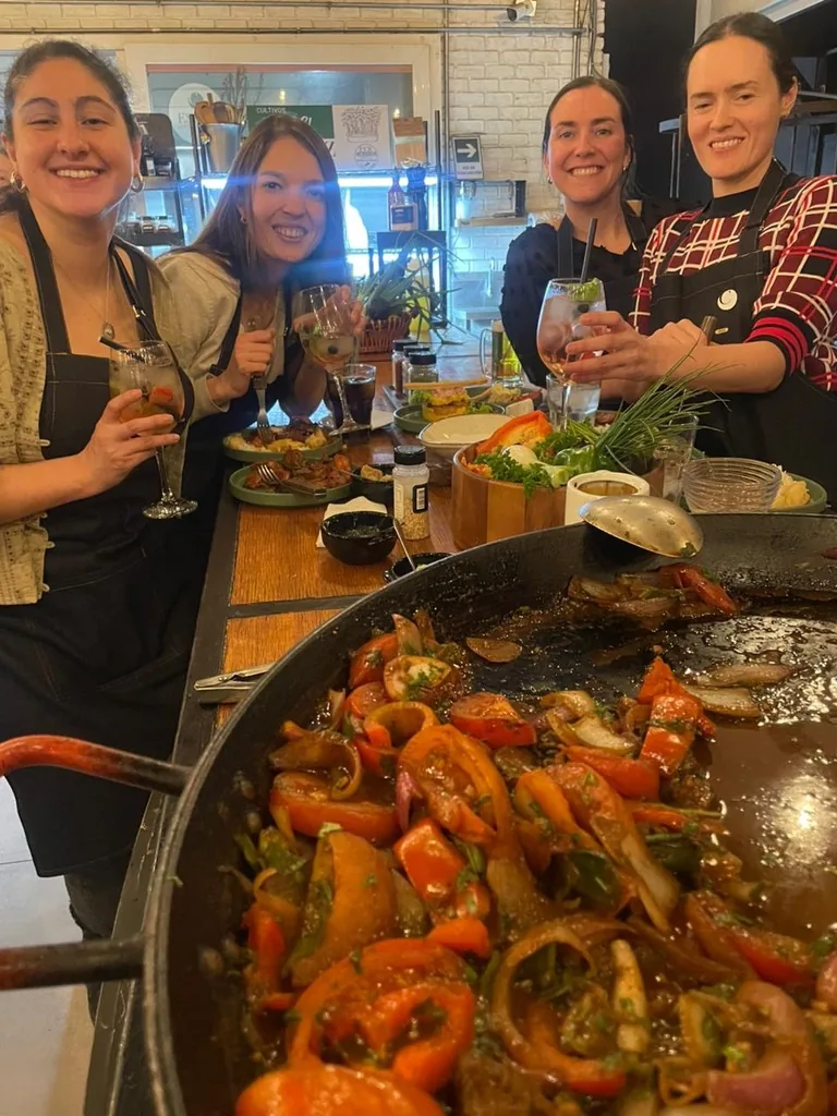 Guests with a finished Chilean dish and drinks after the cooking class
