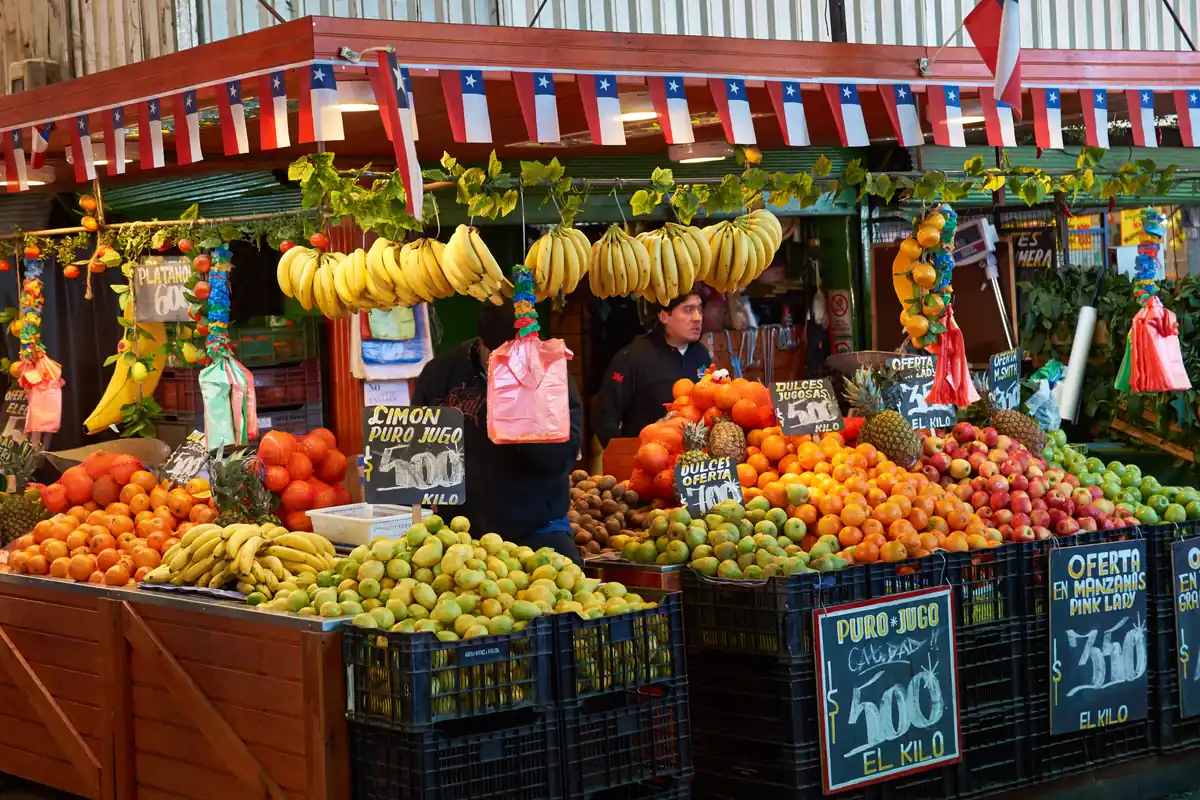 Fruit and vegetable stall with Chilean flags at a Santiago market