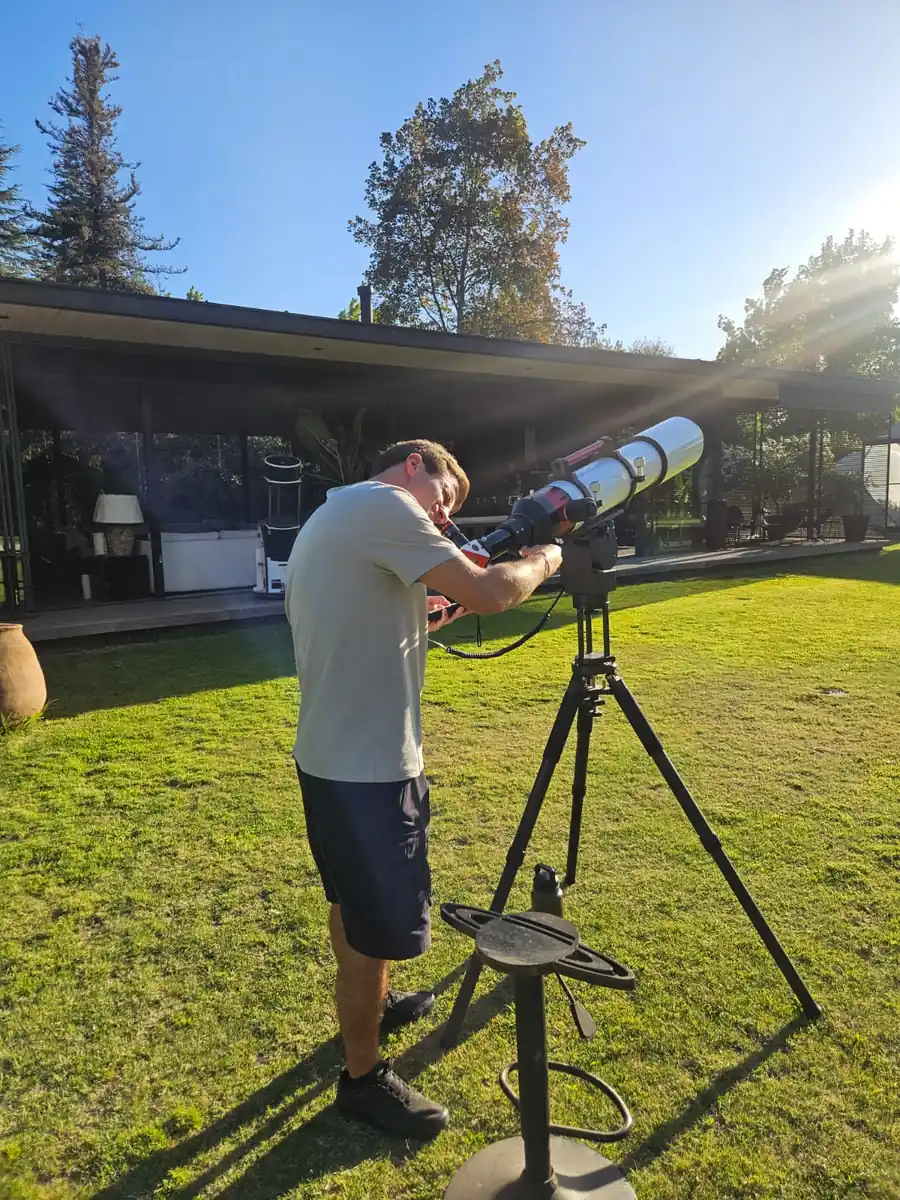 Astronomer setting up a solar telescope in the observatory garden before sunset