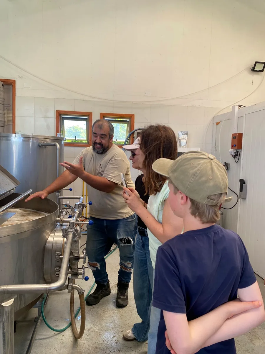 Cheesemaker showing visitors the dairy at a goat cheese producer near Olmué