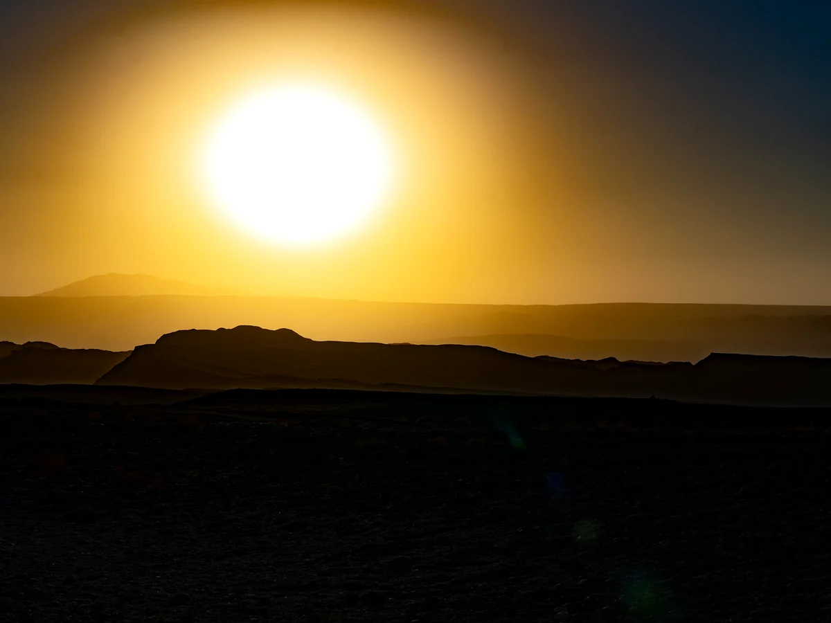 Sun setting over the silhouettes of the Atacama Desert