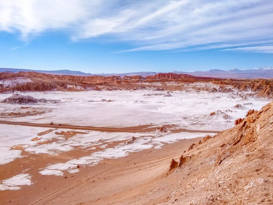 Salt-covered floor of Moon Valley with volcanoes on the horizon