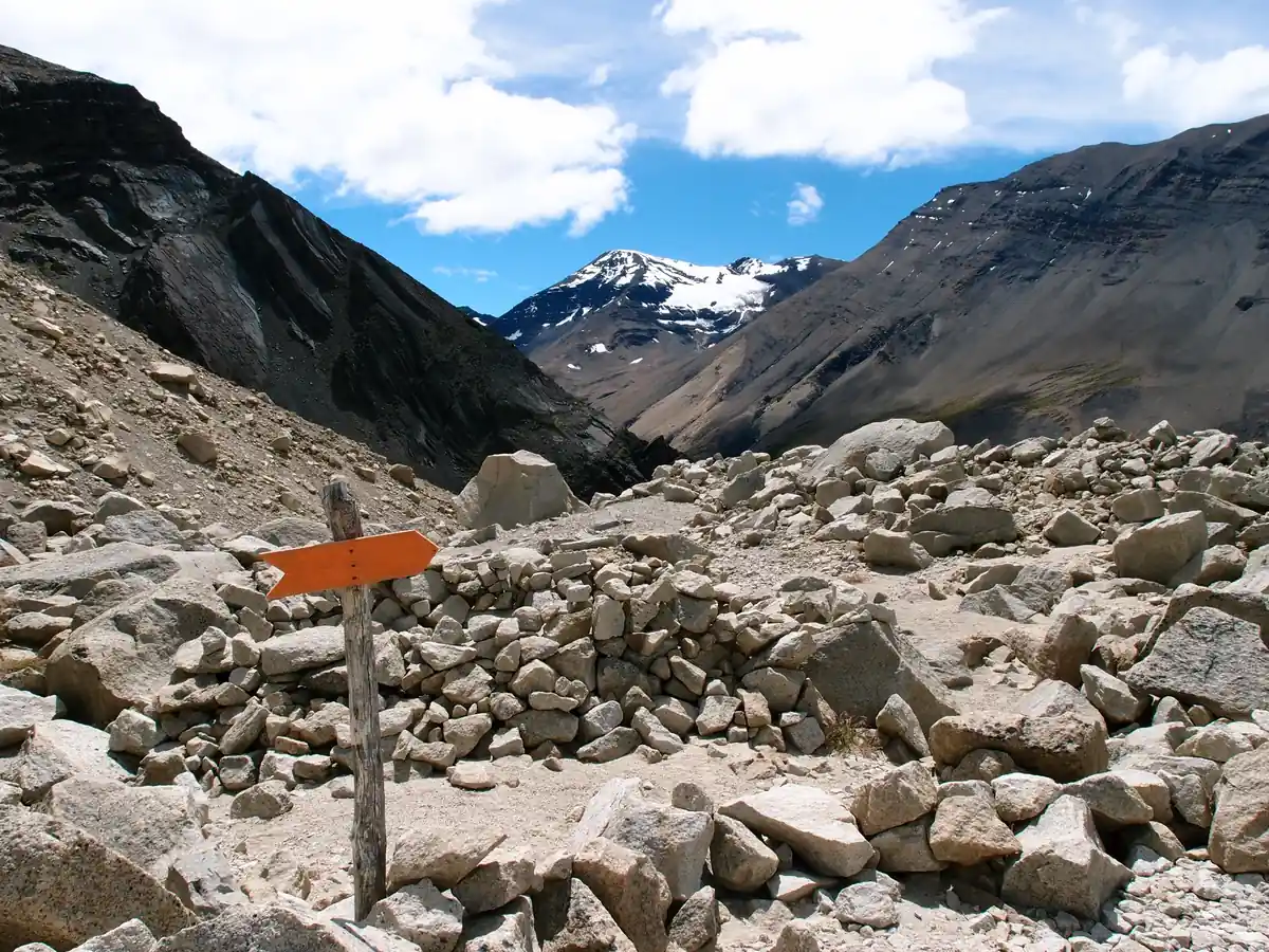 Orange trail marker on the rocky moraine section of the Las Torres trail