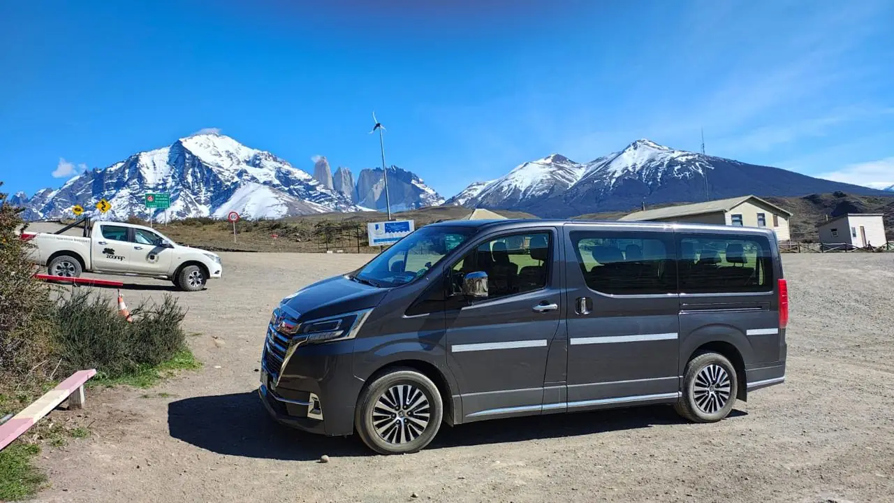 Private transfer van parked in front of the Torres del Paine towers in Chilean Patagonia